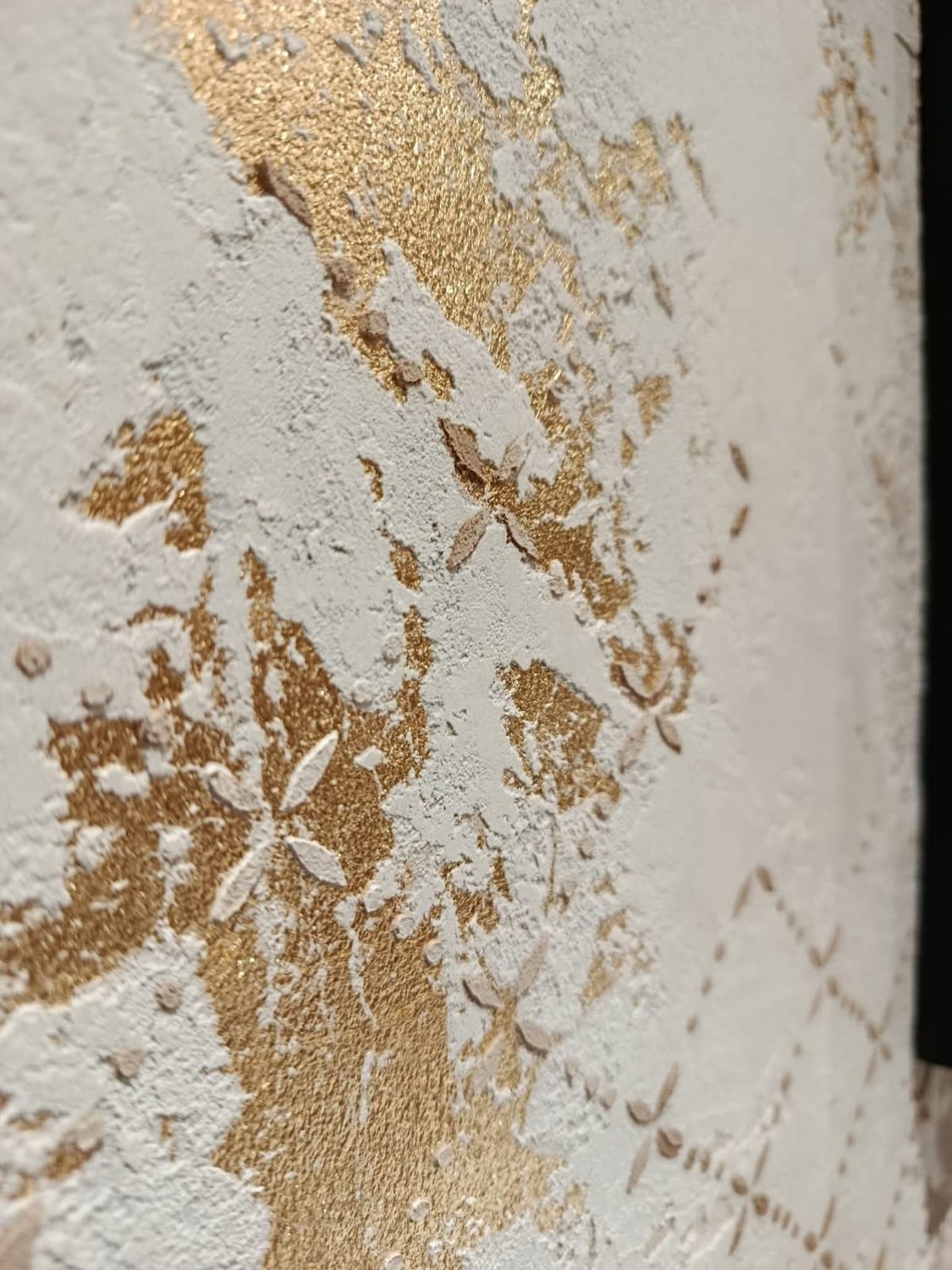 Pared de microcemento con vetas doradas